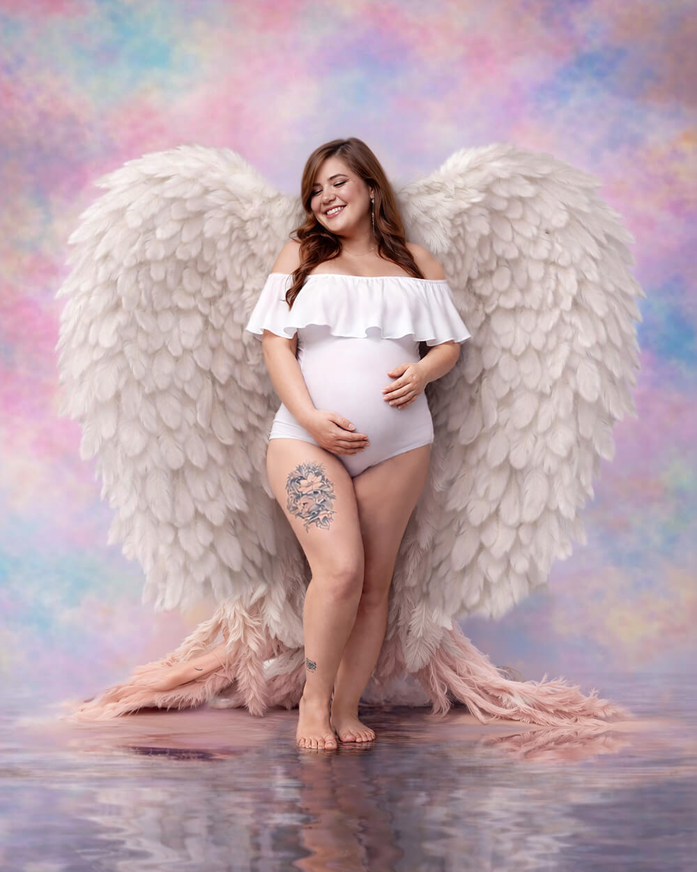Sesión fotográfica artística de embarazo con temática de ángel, mujer con alas blancas y fondo de nubes pasteles en estudio de Cochabamba - 53 Fotografía.